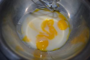 un peu de préparation tiédi sur les jaunes d’œufs 