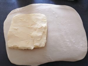 Carré de beurre posé sur une partie de la pâte